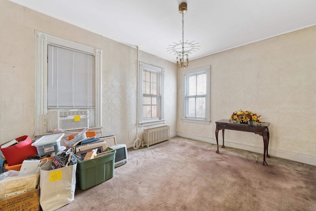 miscellaneous room with radiator heating unit, cooling unit, a notable chandelier, and carpet