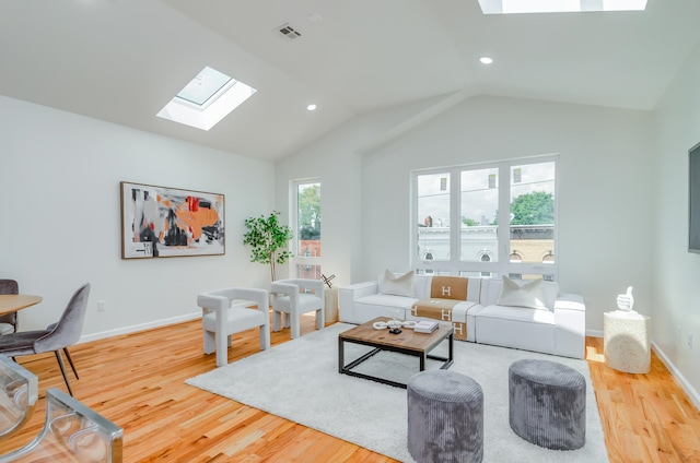 living room featuring wood-type flooring and lofted ceiling with skylight