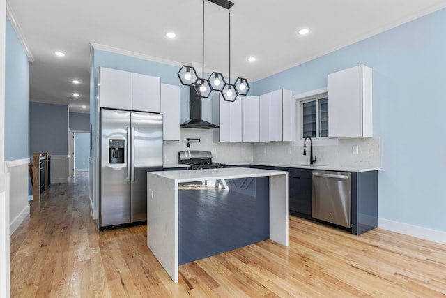 kitchen with ornamental molding, a center island, wall chimney exhaust hood, appliances with stainless steel finishes, and backsplash
