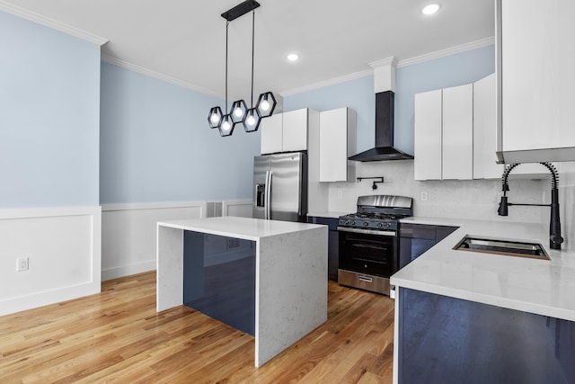 kitchen with a sink, appliances with stainless steel finishes, ornamental molding, and wall chimney exhaust hood