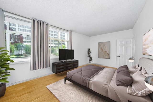 bedroom featuring a textured ceiling and wood-type flooring