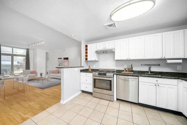 kitchen with light tile patterned floors, stainless steel appliances, and white cabinetry