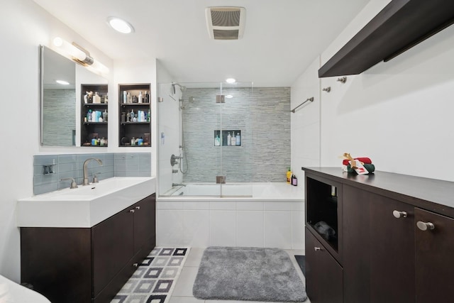 bathroom featuring enclosed tub / shower combo, vanity, tasteful backsplash, and tile patterned flooring