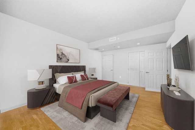 bedroom with a textured ceiling and wood-type flooring