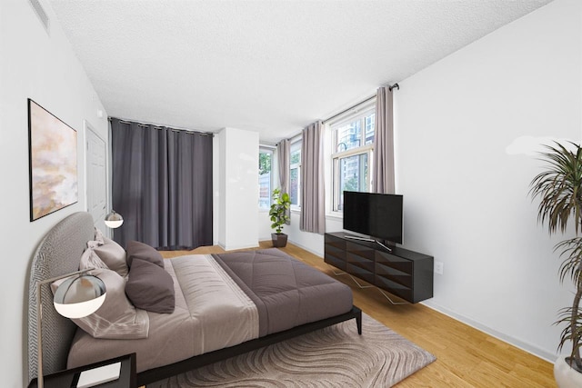 bedroom featuring a textured ceiling and light hardwood / wood-style floors