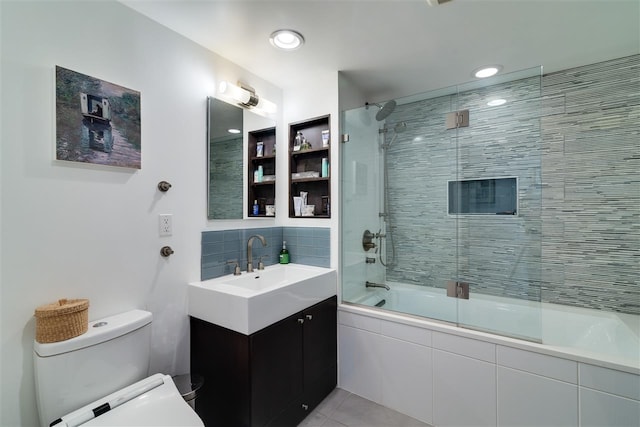 full bathroom with tile patterned floors, bath / shower combo with glass door, toilet, and vanity