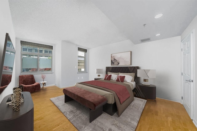 bedroom with a textured ceiling and light hardwood / wood-style floors