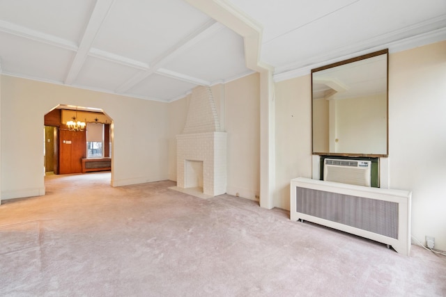 unfurnished living room featuring a notable chandelier, arched walkways, radiator, carpet, and a fireplace