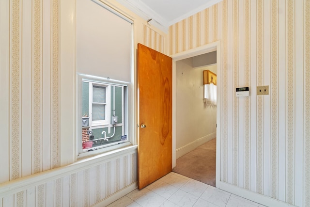 corridor with ornamental molding and wallpapered walls