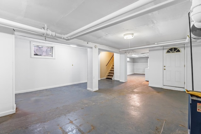 finished basement featuring stairway and baseboards