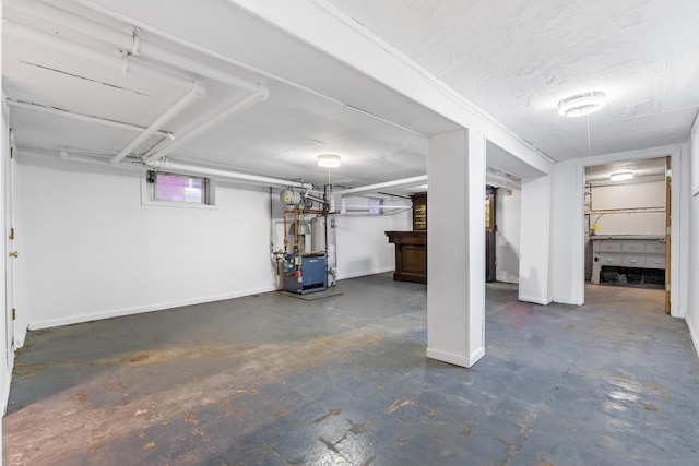 basement with baseboards and a textured ceiling