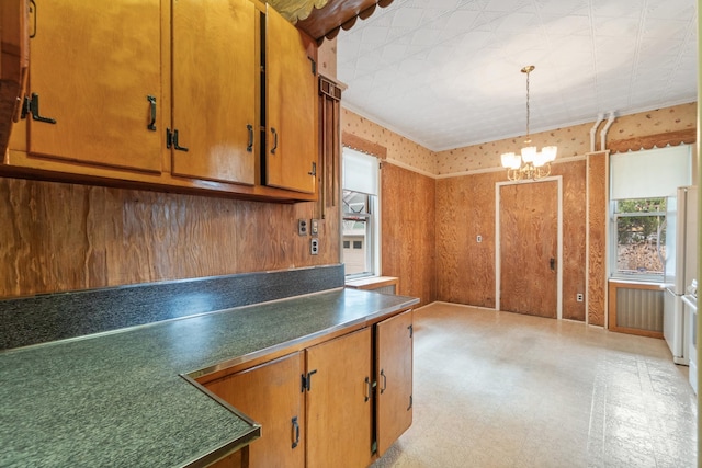 kitchen featuring a notable chandelier, dark countertops, freestanding refrigerator, wallpapered walls, and light floors