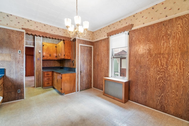 kitchen with dark countertops, a notable chandelier, light floors, and brown cabinets