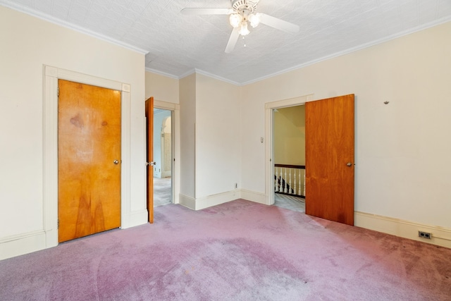 unfurnished room featuring crown molding, a ceiling fan, baseboards, and carpet floors