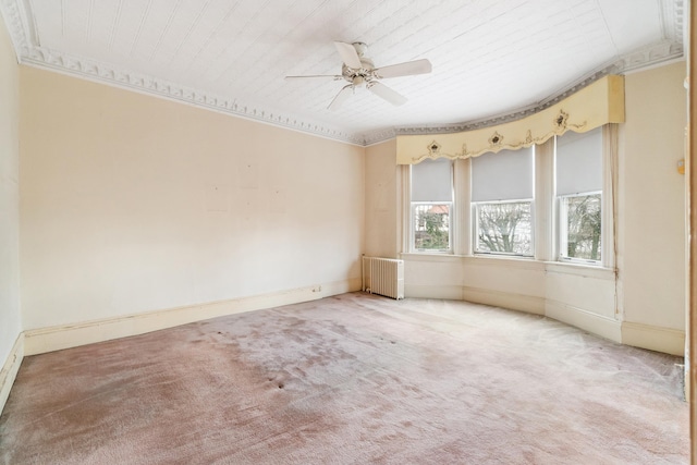 carpeted empty room featuring radiator, a ceiling fan, and baseboards