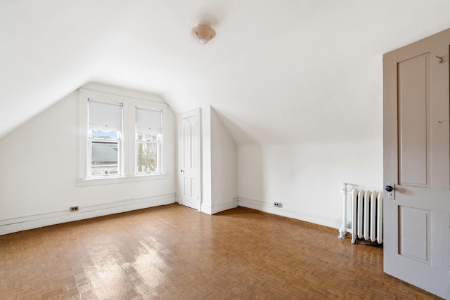 additional living space featuring a baseboard radiator, baseboards, radiator, and vaulted ceiling