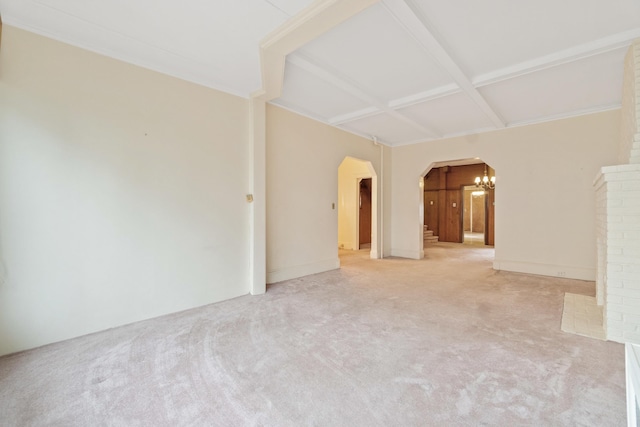 spare room featuring coffered ceiling, beam ceiling, an inviting chandelier, arched walkways, and light carpet