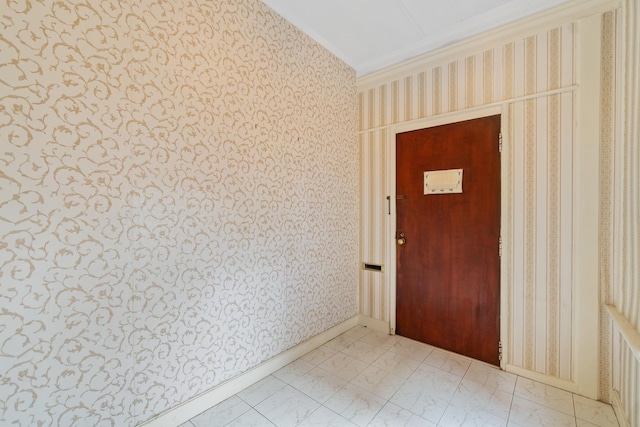 spare room featuring marble finish floor, ornamental molding, and wallpapered walls