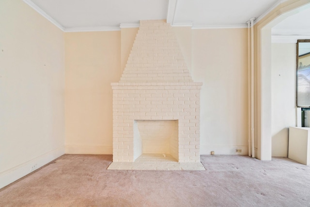 unfurnished living room featuring crown molding, a brick fireplace, baseboards, and carpet floors