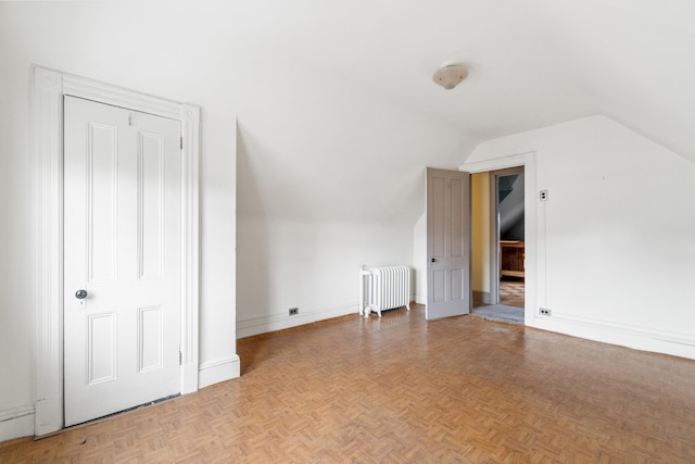 bonus room featuring baseboards, lofted ceiling, and radiator