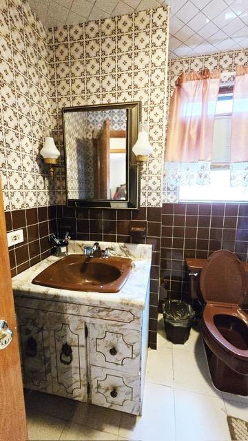 372 9th St, Fairview, NJ 07022 - half bath featuring tile walls, wallpapered walls, wainscoting, vanity, and tile patterned floors