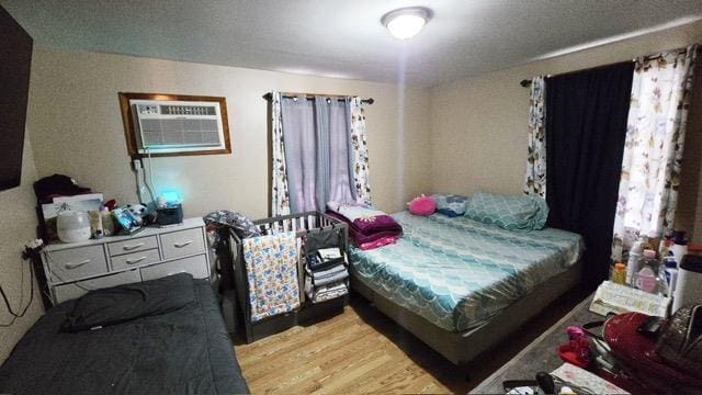 372 9th St, Fairview, NJ 07022 - bedroom with light wood-type flooring and a wall mounted air conditioner