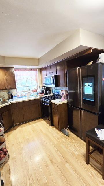 372 9th St, Fairview, NJ 07022 - kitchen featuring stainless steel appliances, light wood finished floors, light countertops, and dark brown cabinets