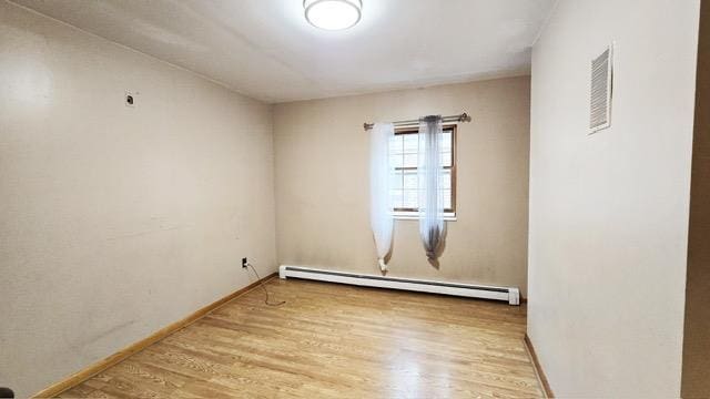 372 9th St, Fairview, NJ 07022 - empty room featuring a baseboard heating unit and wood finished floors