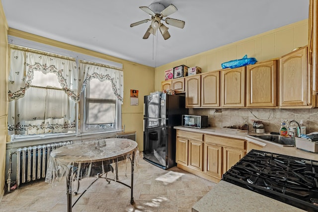 kitchen with radiator, black appliances, sink, ceiling fan, and decorative backsplash