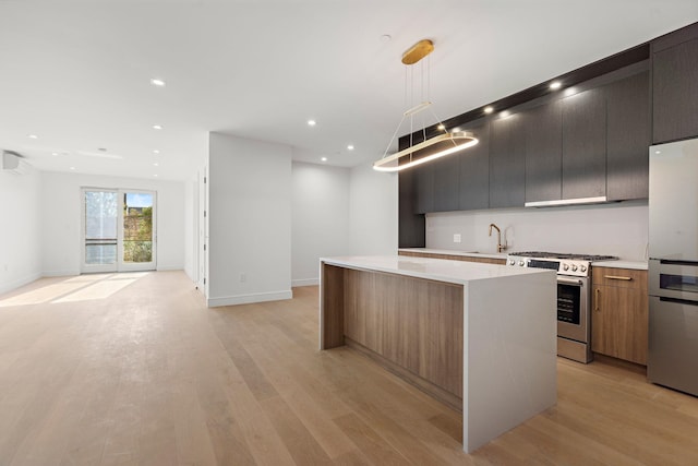 kitchen featuring a sink, appliances with stainless steel finishes, modern cabinets, open floor plan, and a center island