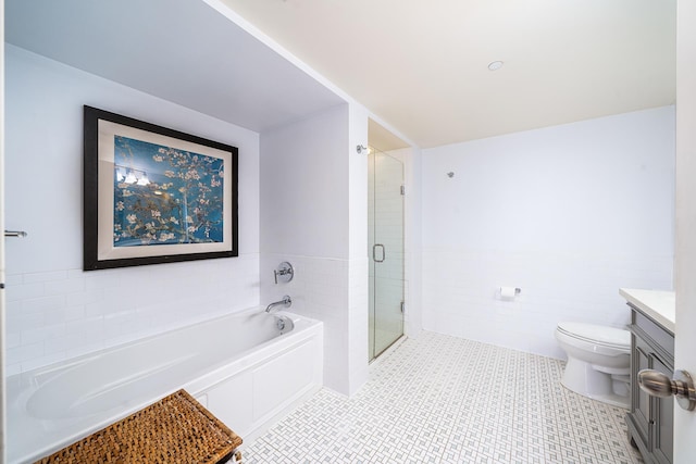 700 Grove St Unit 11P, Jersey City, NJ 07310 - bathroom featuring a garden tub, vanity, tile walls, tile patterned floors, and a wainscoted wall