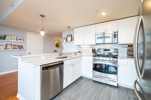 700 Grove St Unit 11P, Jersey City, NJ 07310 - kitchen with stainless steel appliances, a peninsula, backsplash, white cabinetry, and recessed lighting