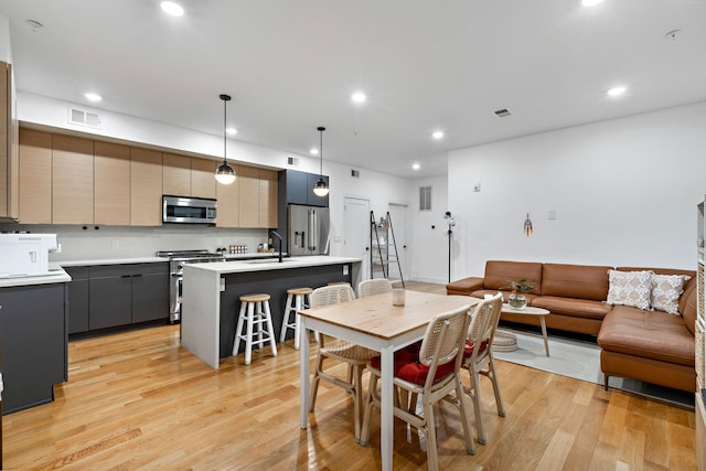 dining room with sink and light hardwood / wood-style flooring