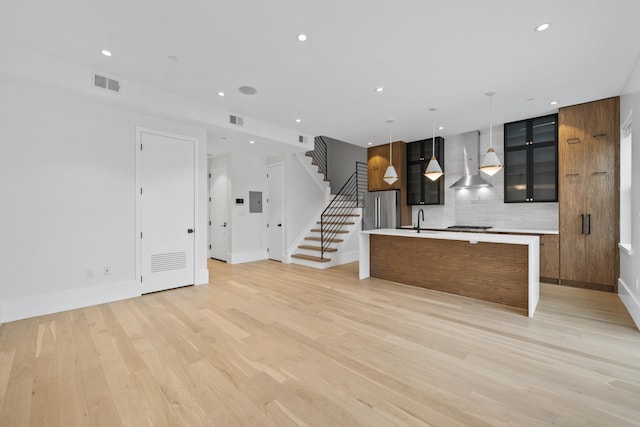 unfurnished living room with light wood-style floors, recessed lighting, visible vents, and stairway