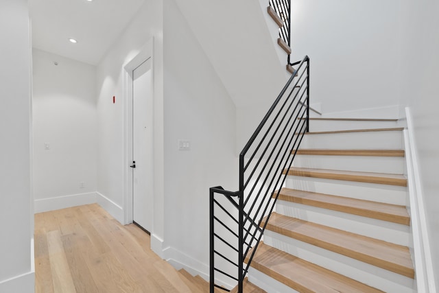 staircase with recessed lighting, baseboards, and wood finished floors