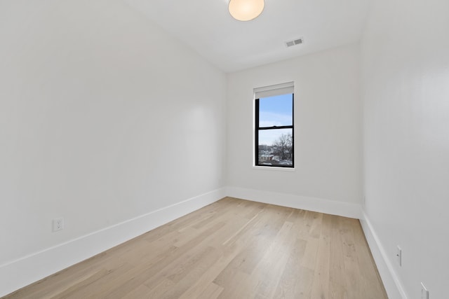 unfurnished room featuring baseboards, visible vents, and light wood finished floors