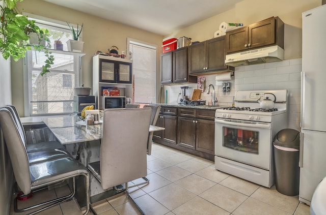 400 67th St, West New York, NJ 07093 - kitchen featuring white appliances, under cabinet range hood, backsplash, and dark brown cabinets