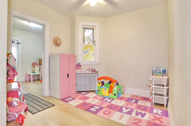 400 67th St, West New York, NJ 07093 - playroom featuring radiator heating unit, ceiling fan, and wood finished floors