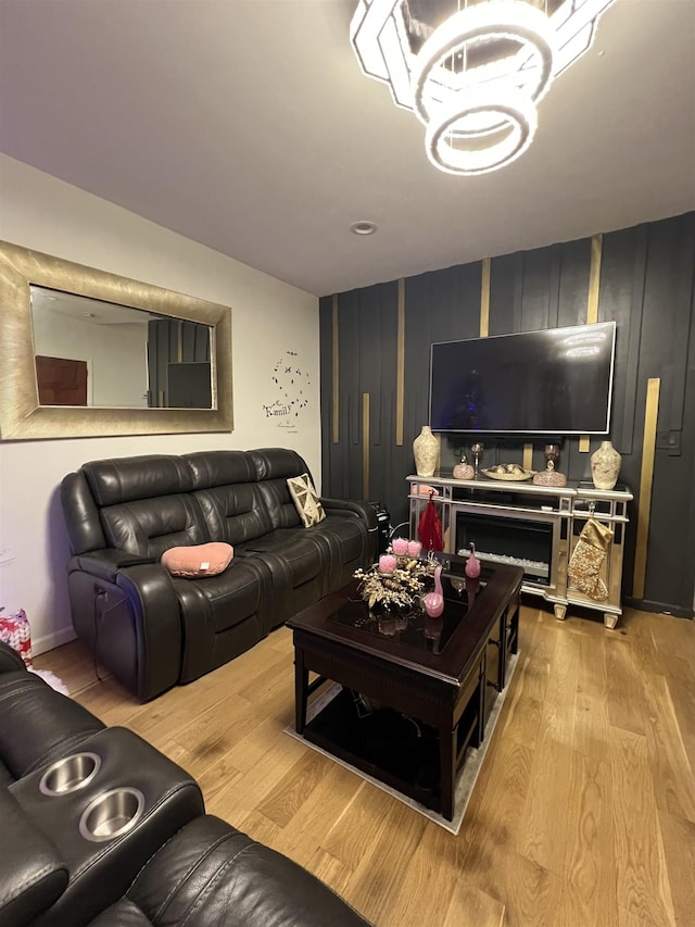 living room featuring a notable chandelier and light wood-type flooring