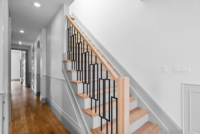 166 New York Ave Unit 2, Jersey City, NJ 07307 - stairs featuring arched walkways, wood finished floors, recessed lighting, and a wainscoted wall