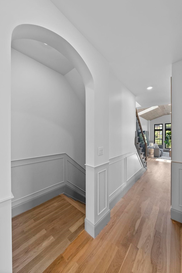 166 New York Ave Unit 2, Jersey City, NJ 07307 - corridor with wood finished floors, vaulted ceiling, stairs, a wainscoted wall, and arched walkways