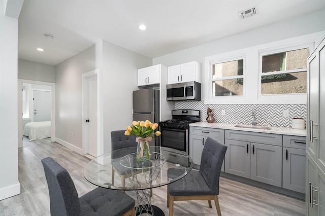 dining area with light wood-style flooring, recessed lighting, baseboards, and visible vents