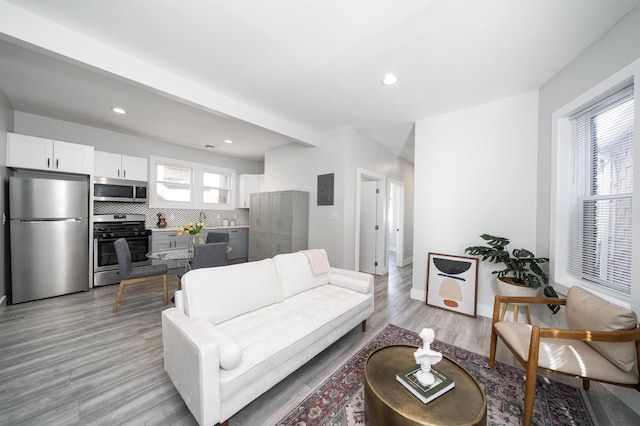 living room with recessed lighting, a healthy amount of sunlight, and light wood-style flooring