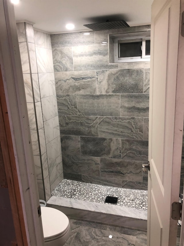 bathroom featuring toilet and tiled shower