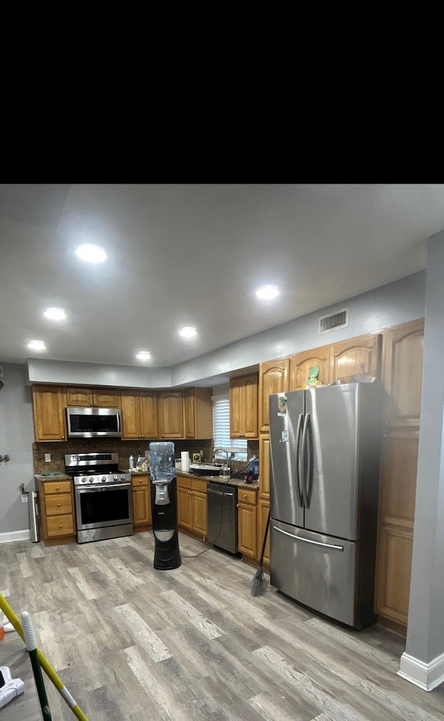 kitchen featuring stainless steel appliances, sink, and light hardwood / wood-style floors