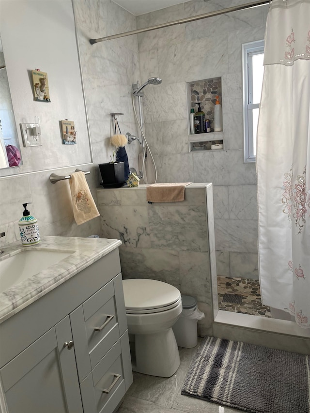 bathroom featuring walk in shower, vanity, toilet, and tile walls