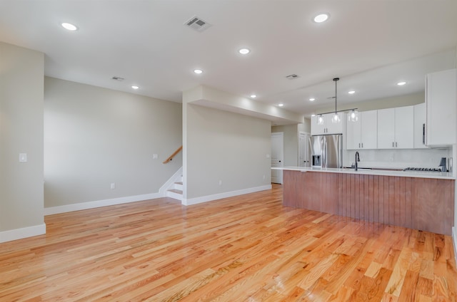 kitchen featuring light countertops, light wood-style flooring, and stainless steel fridge with ice dispenser