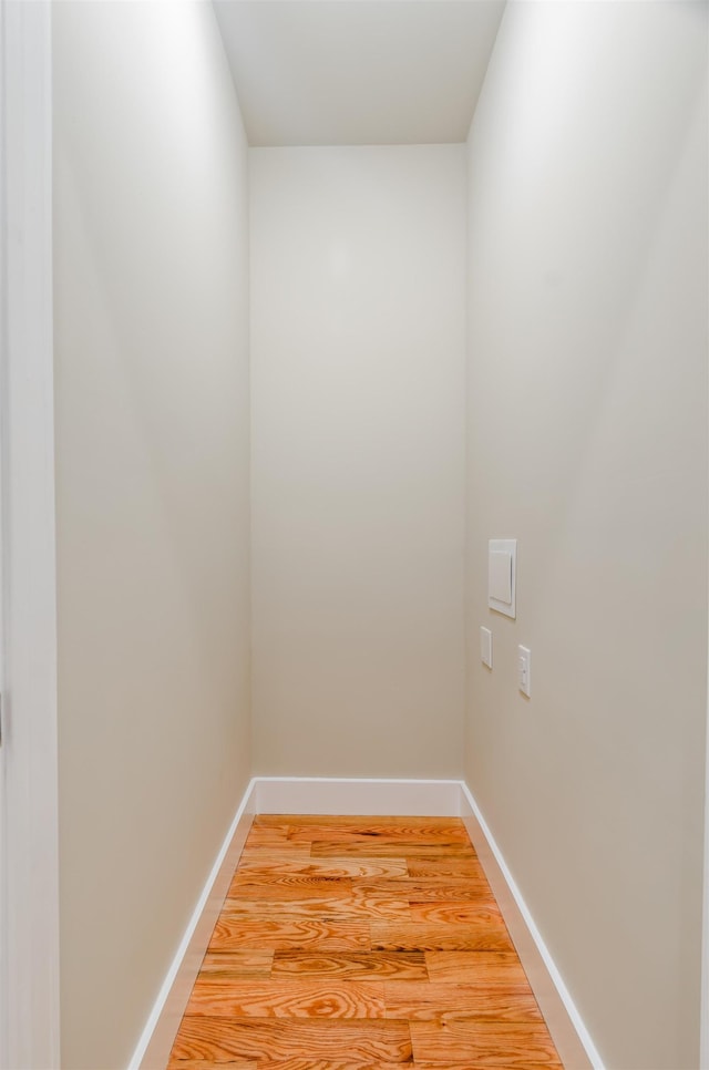 laundry room with light wood finished floors and baseboards