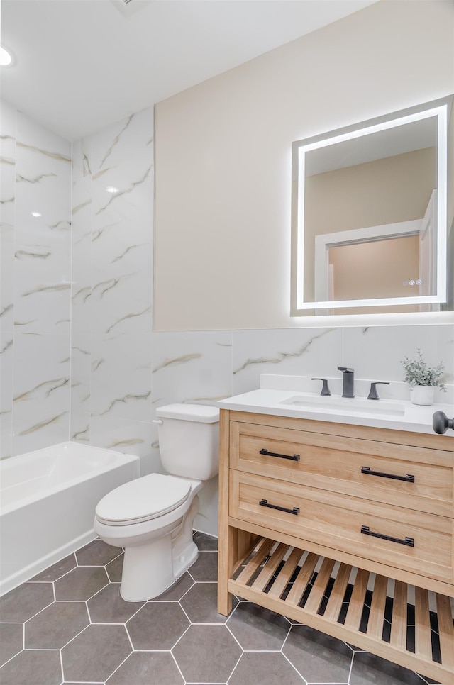 full bath featuring tile patterned flooring, vanity, toilet, and tile walls