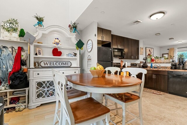 437 Rose Ave, Jersey City, NJ 07305 - kitchen with black appliances, dark brown cabinetry, light countertops, and a sink